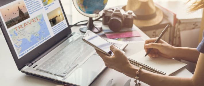 Seven Reasons to Plan a Staycation Young woman planning vacation trip and searching information or booking an hotel on a smart phone and laptop