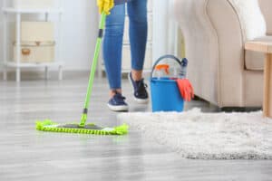 Female janitor mopping floor in room