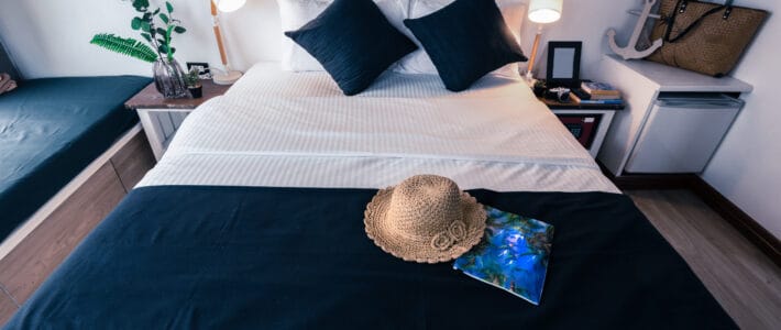 A bedroom in a vacation rental Airbnb with a modern-style bed with a black runner sheet and black pillows.