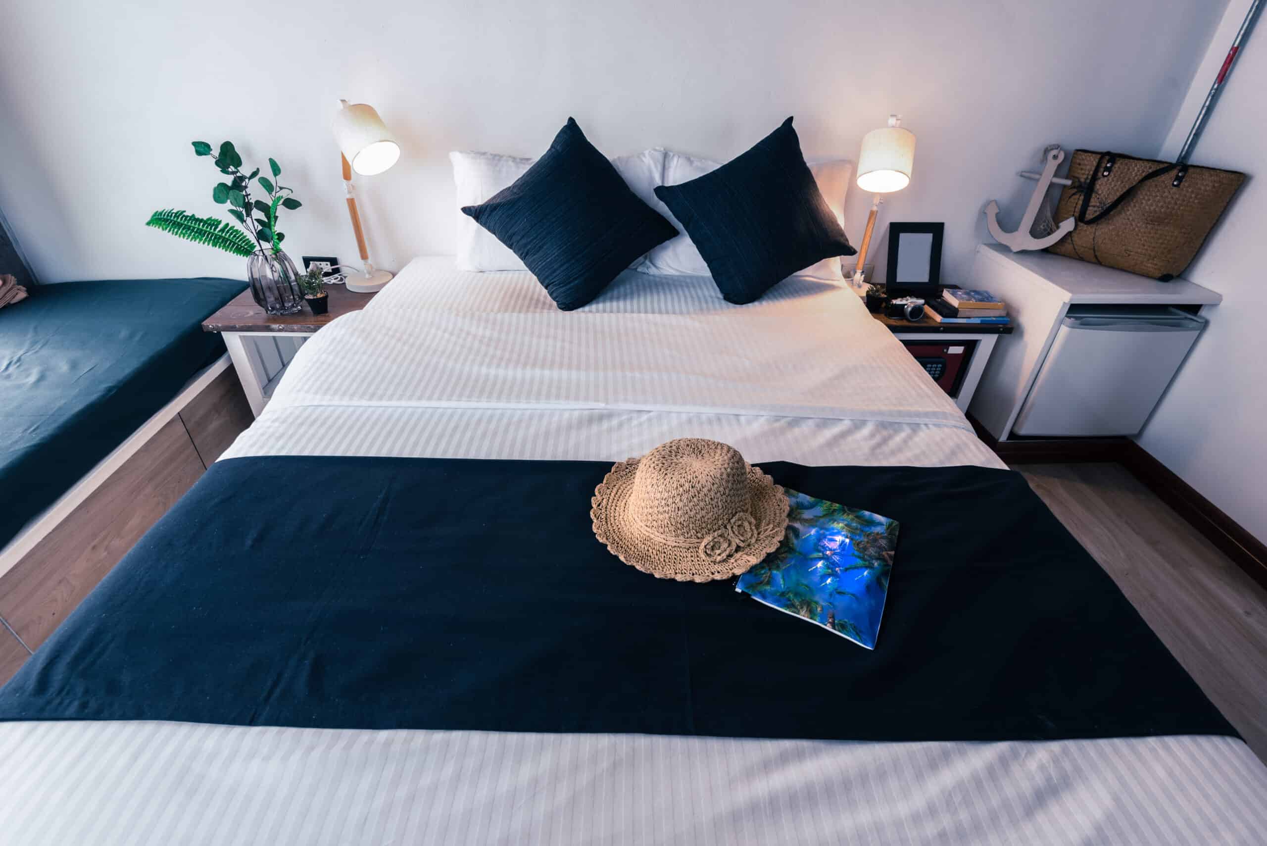 A bedroom in a vacation rental Airbnb with a modern-style bed with a black runner sheet and black pillows.