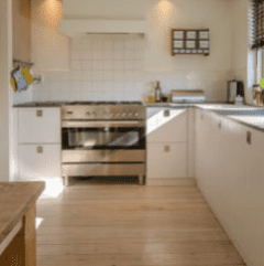 Kitchen inside an Airbnb rental with white cabinetry that has been professionally cleaned by The Magic Helpers.