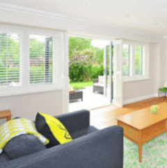 The living room of a rental home with French doors that lead to an outdoor sitting area.