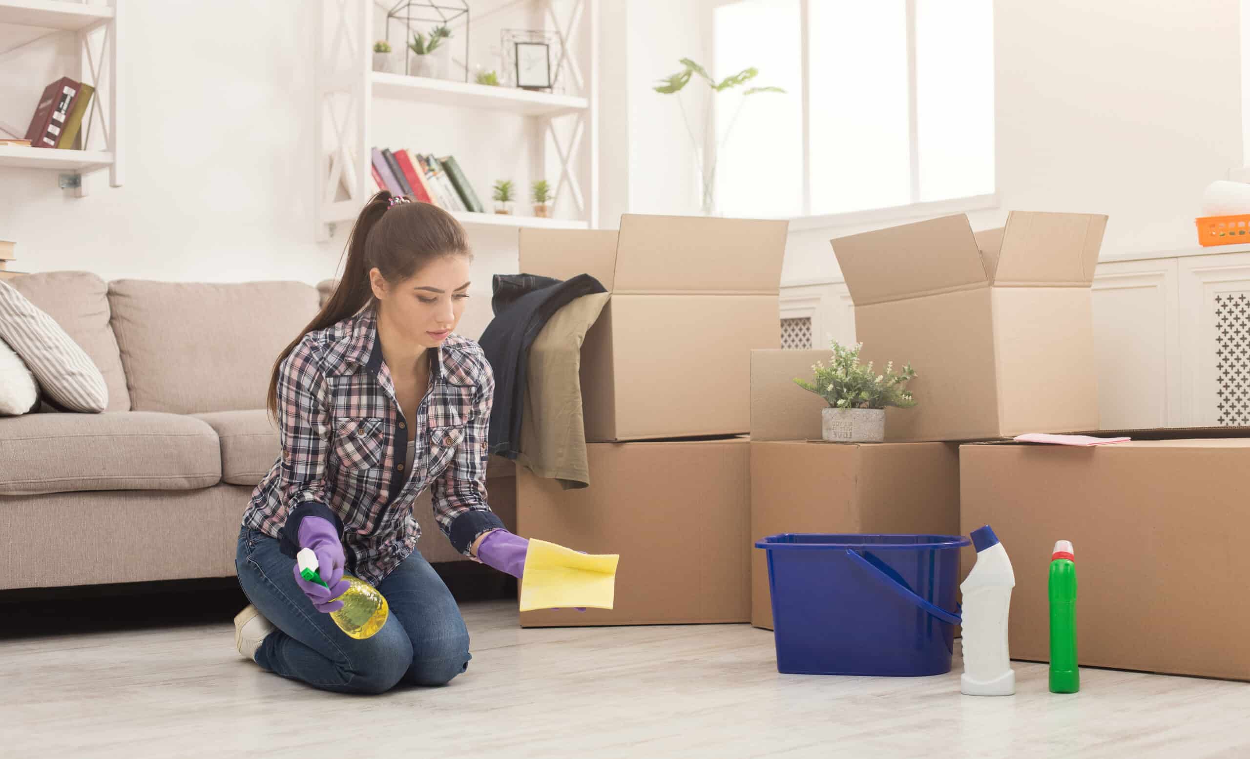Airbnb Cleaning Services: How Should You Clean a Rental House Before Moving In? Lady cleaning a rental house by mopping the floors with a sponge and a spray bottle full of cleaning products.