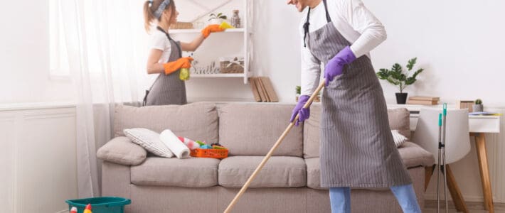 What Do Residential Cleaning Services Do? Two members of The Magic Helpers residential cleaning team mopping and dusting a customer's home.