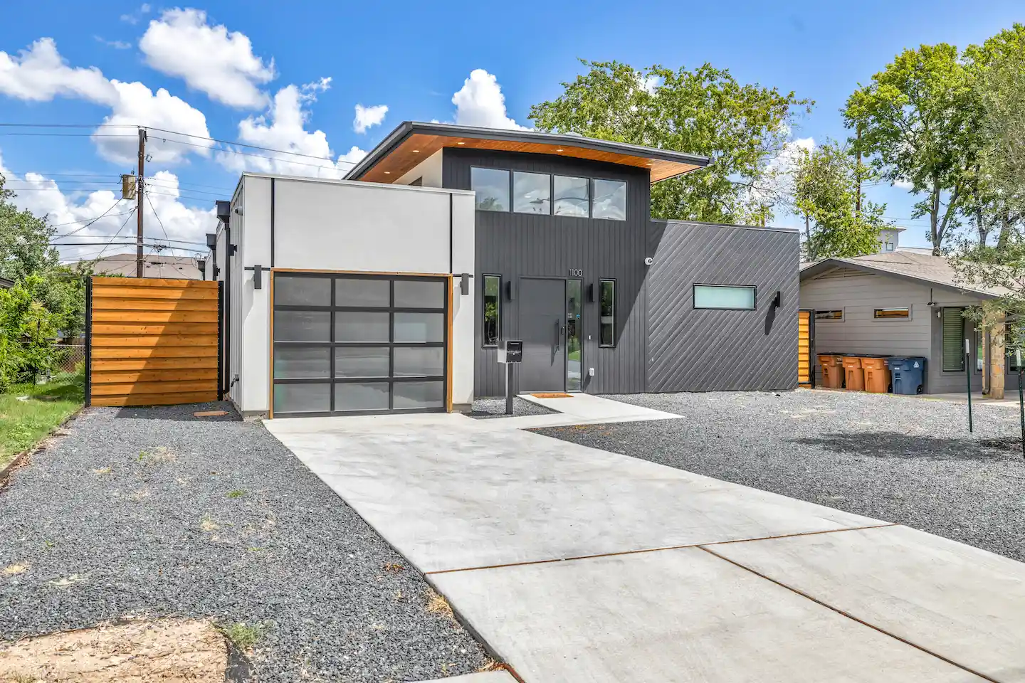 Rental property in Austin, Texas with gray, industrial exterior and orange wooden accents.